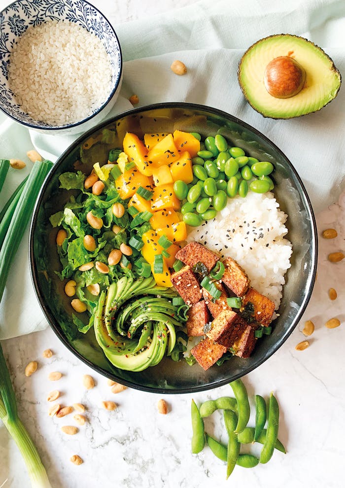A vibrant vegan Buddha bowl with rice, avocado, tofu, and vegetables.